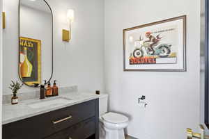 Vanity featuring a stone countertop, integrated rectangular sink, and matte black faucet