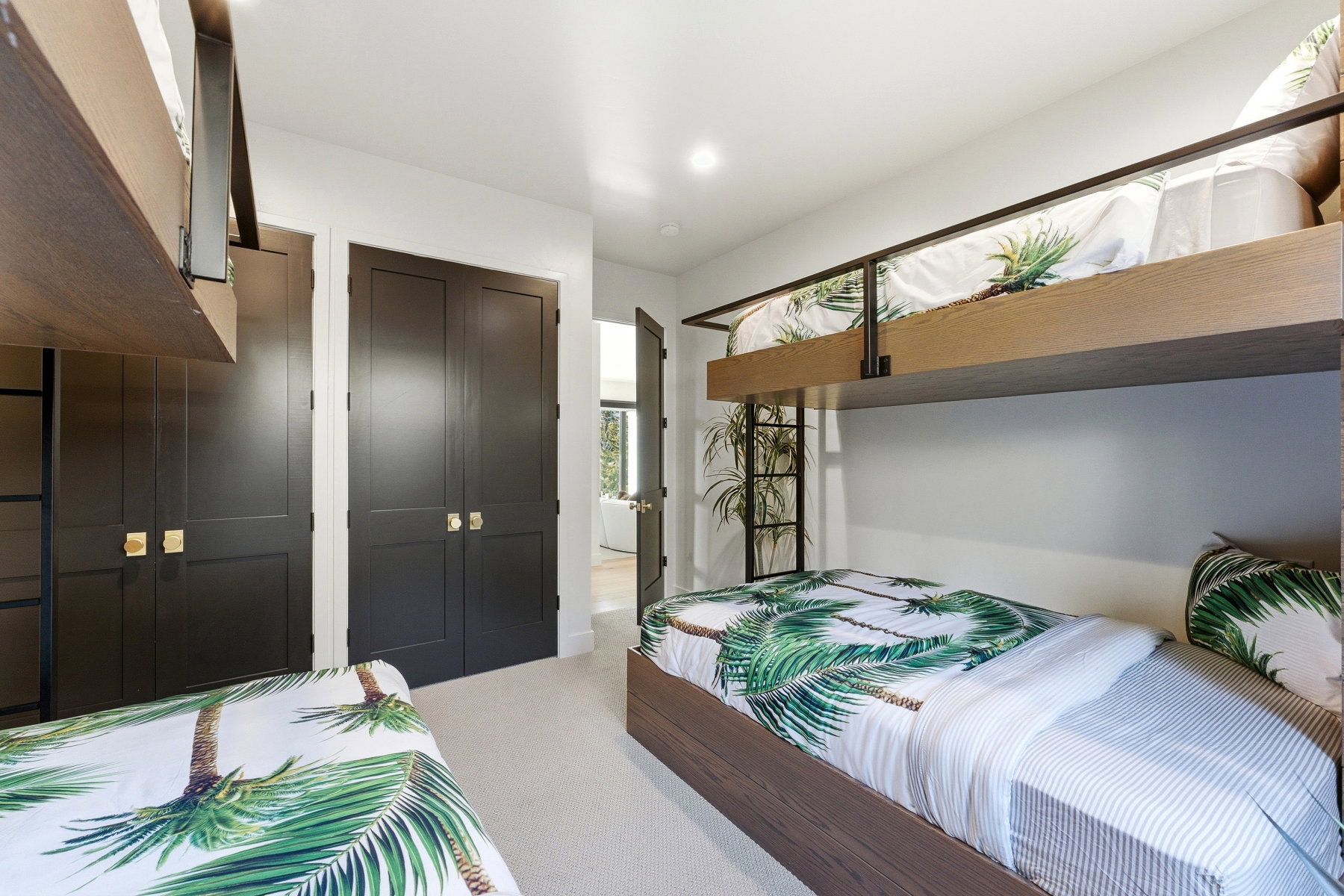 Carpeted bedroom featuring built-in bunk beds with wood-finish frames and metal railings
