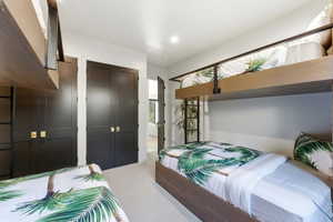 Carpeted bedroom featuring built-in bunk beds with wood-finish frames and metal railings