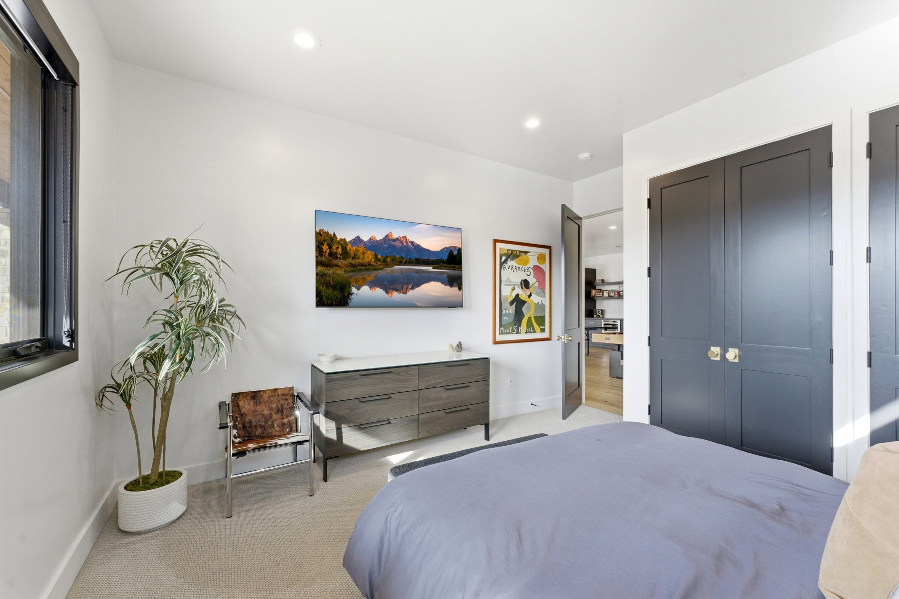 Bedroom featuring light-toned carpeting, recessed lighting, and a dark-framed window