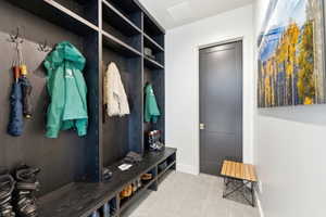 Built-in mudroom storage featuring dark wood-finish cabinetry, integrated shelving, and bench seating