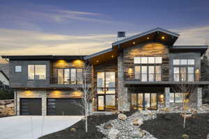 Contemporary residence featuring a multi-material facade of stone and wood-finish siding