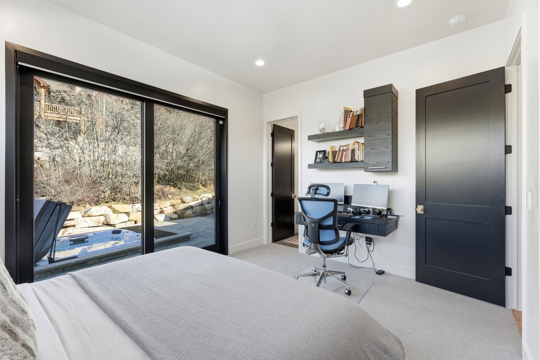 Sliding glass doors opening to a private patio with a built-in spa