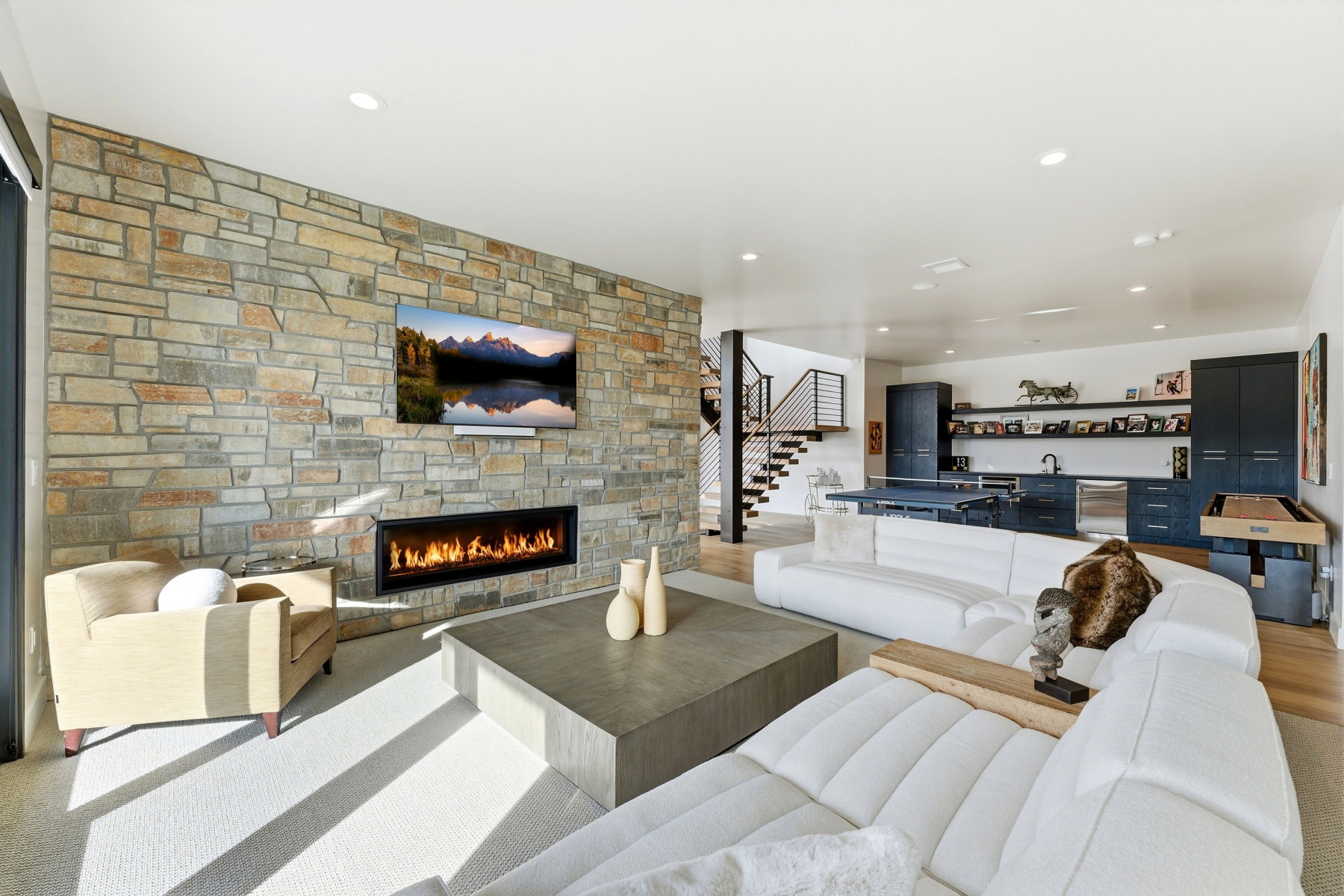 Expansive living area featuring a full-height stone fireplace surround with an integrated linear fireplace