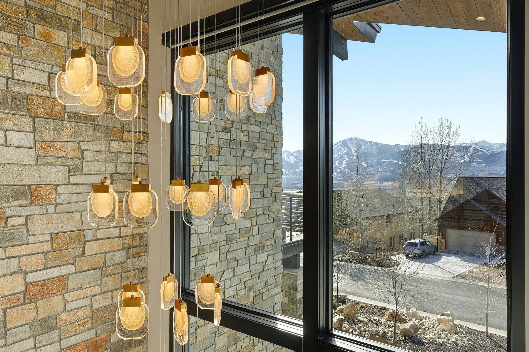 Multi-tiered chandelier with geometric glass pendants and brass accents