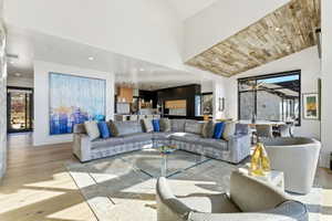 Spacious living area featuring high vaulted ceilings and light wood-finish flooring