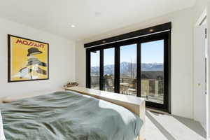 Floor-to-ceiling sliding glass doors open to a balcony with mountain scenery