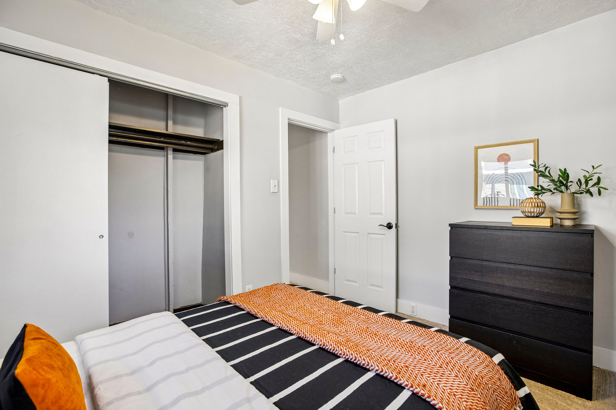 Bedroom with light gray walls, white trim, and a ceiling fan