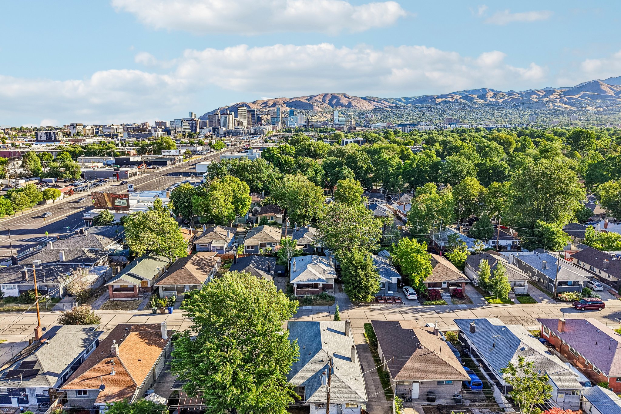 Aerial perspective showcasing an established neighborhood with a mix of residential structures and mature trees