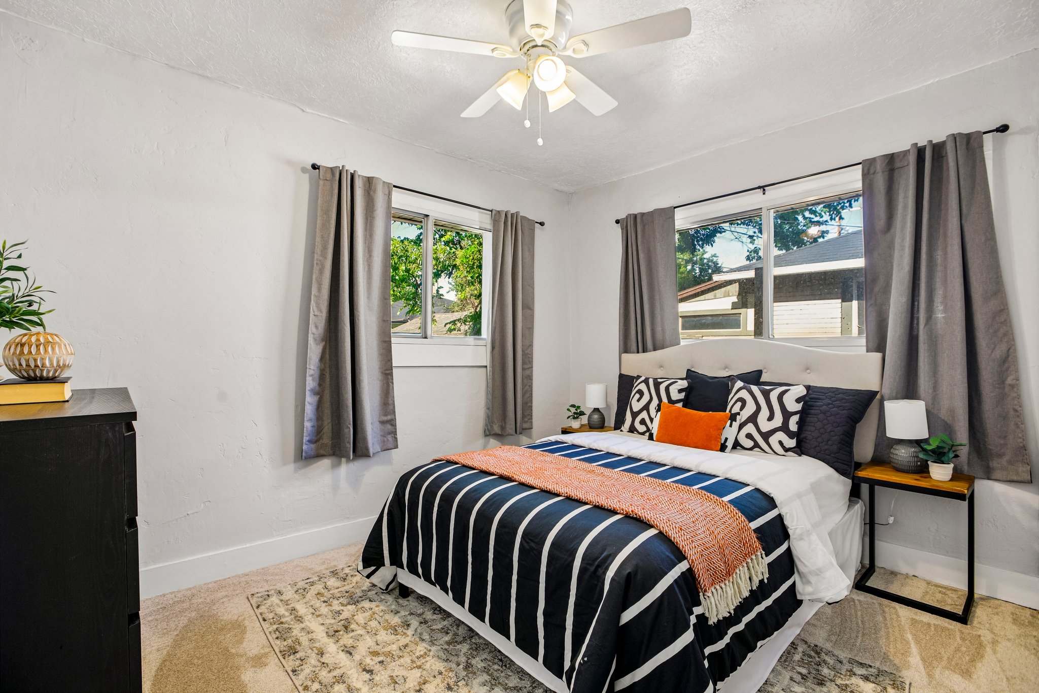 Bedroom with two windows, a ceiling fan, and light-colored walls