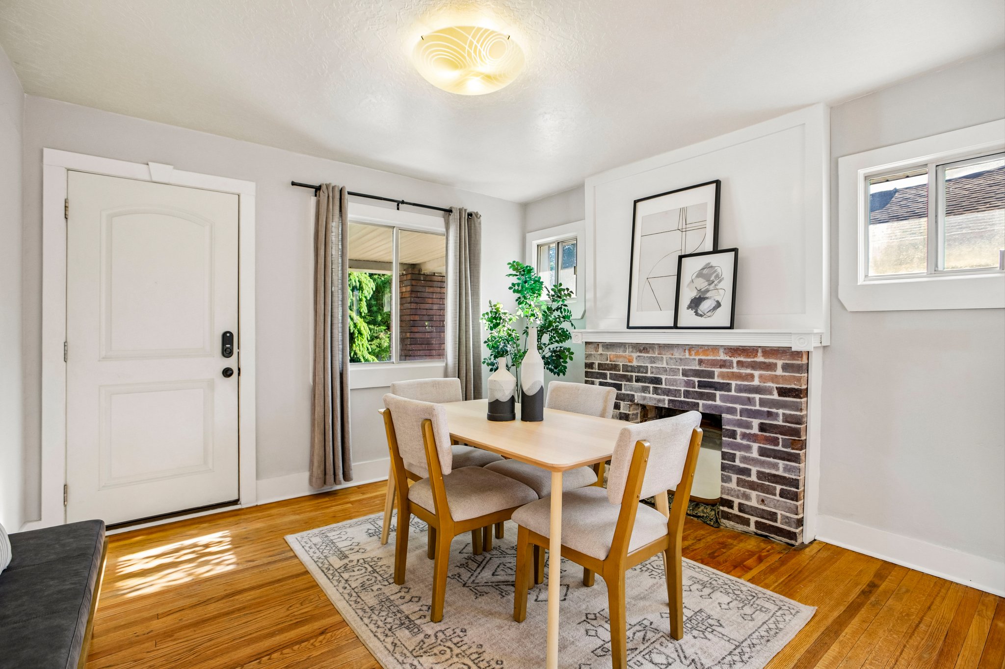 Interior space featuring wood-finish flooring, a white paneled door, and a brick fireplace
