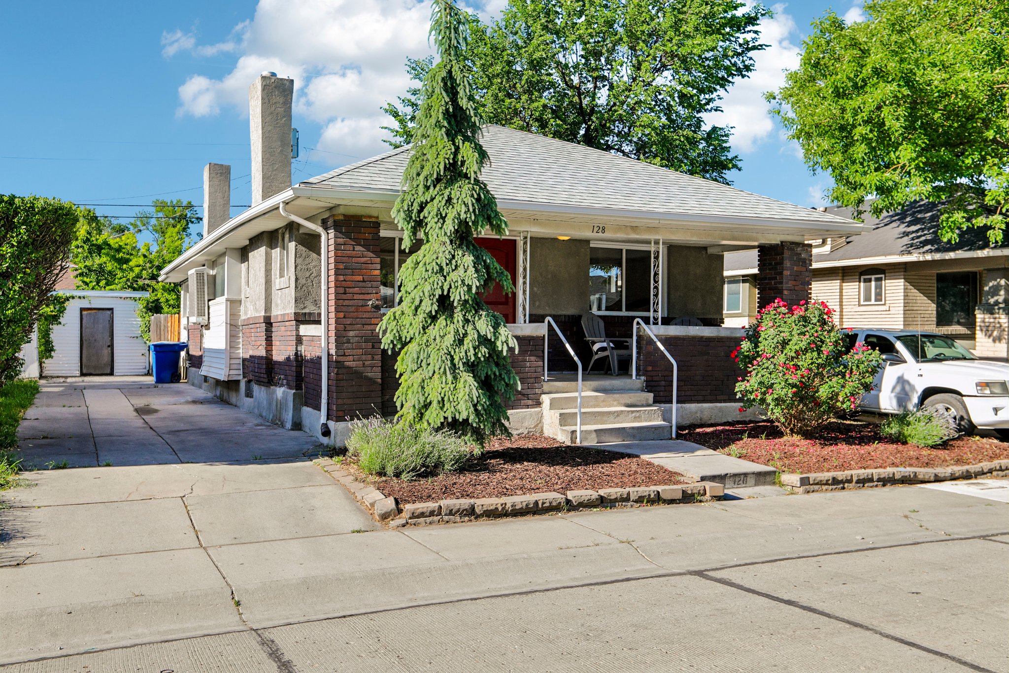 Brick and stucco exterior with a covered front porch featuring white railings