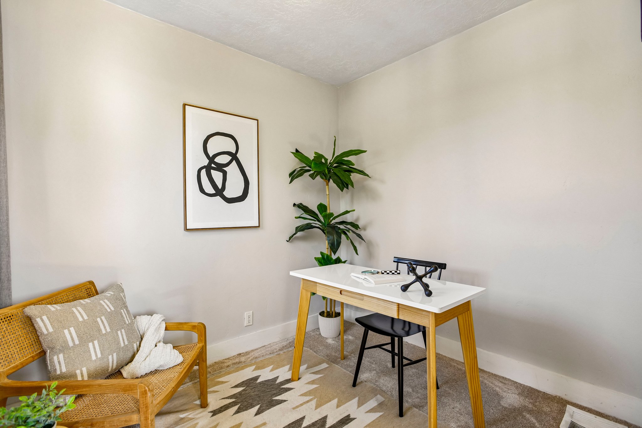 Neutral wall finishes compliment wood-finish flooring with a geometric area rug