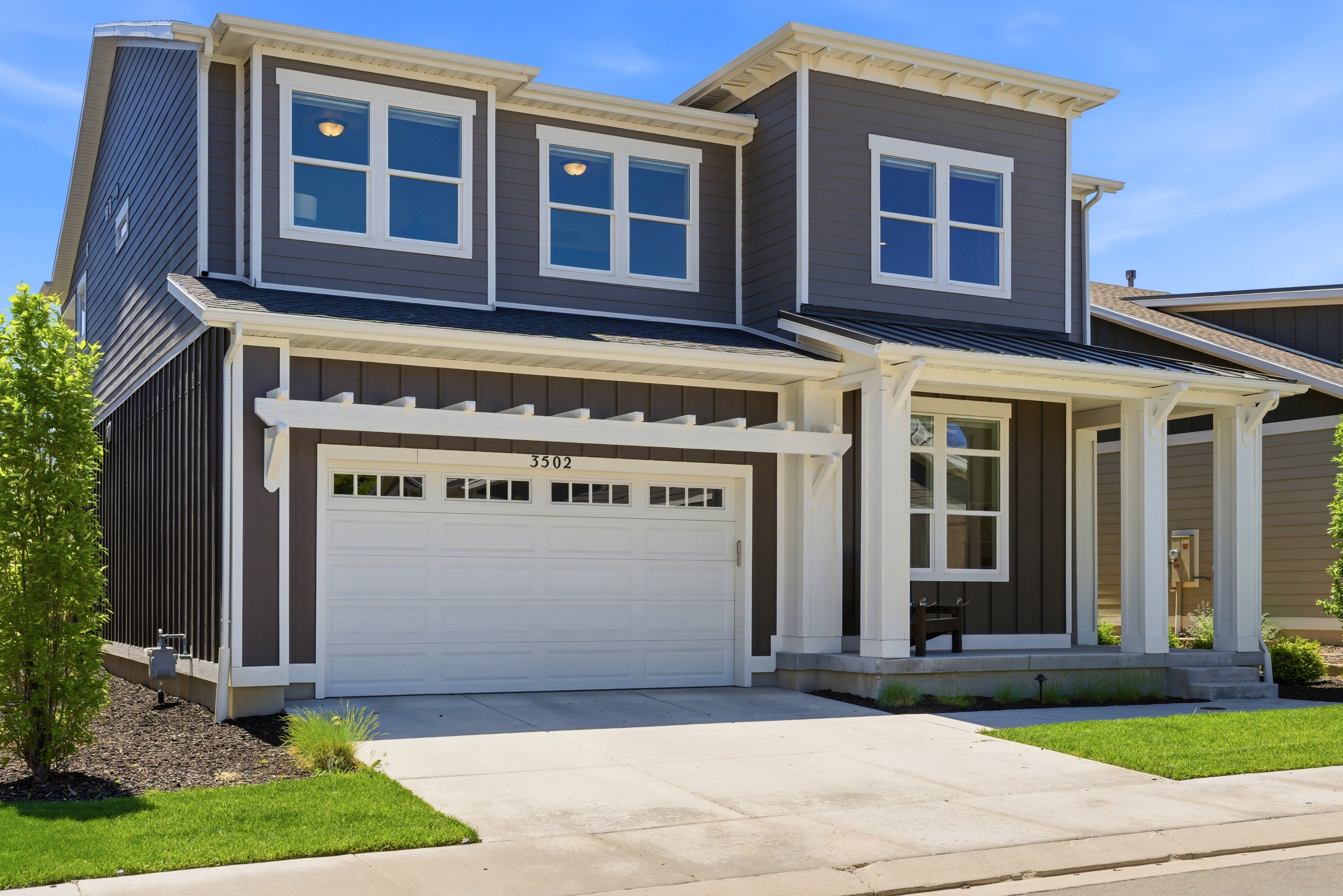 Contemporary two-story residence featuring a dark gray and black exterior with white trim
