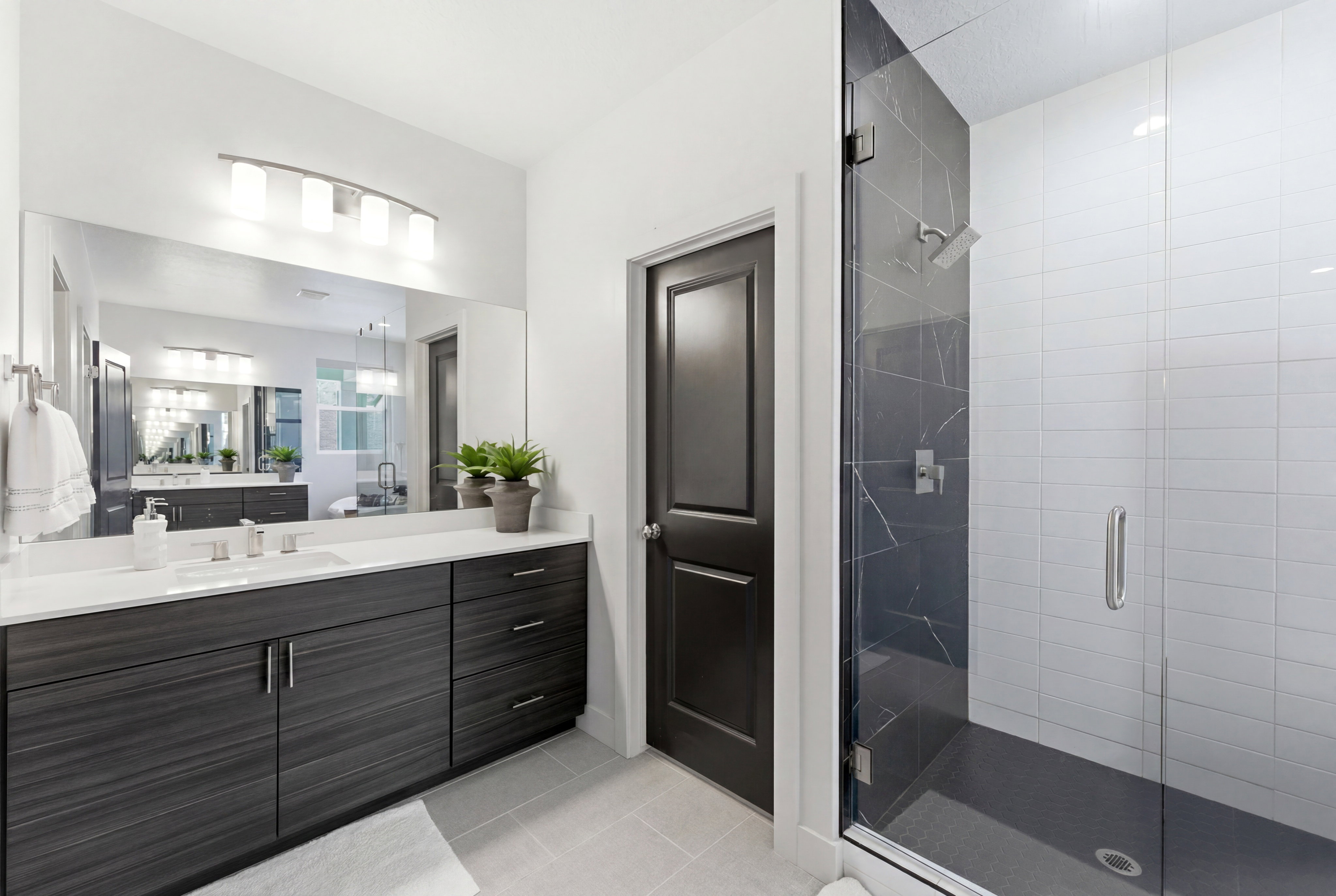 Vanity featuring a white countertop with an undermount sink, wood-finish cabinetry, and a wide mirror