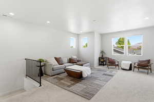 Spacious upper-level room featuring multiple windows, recessed lighting, and light-colored carpeting
