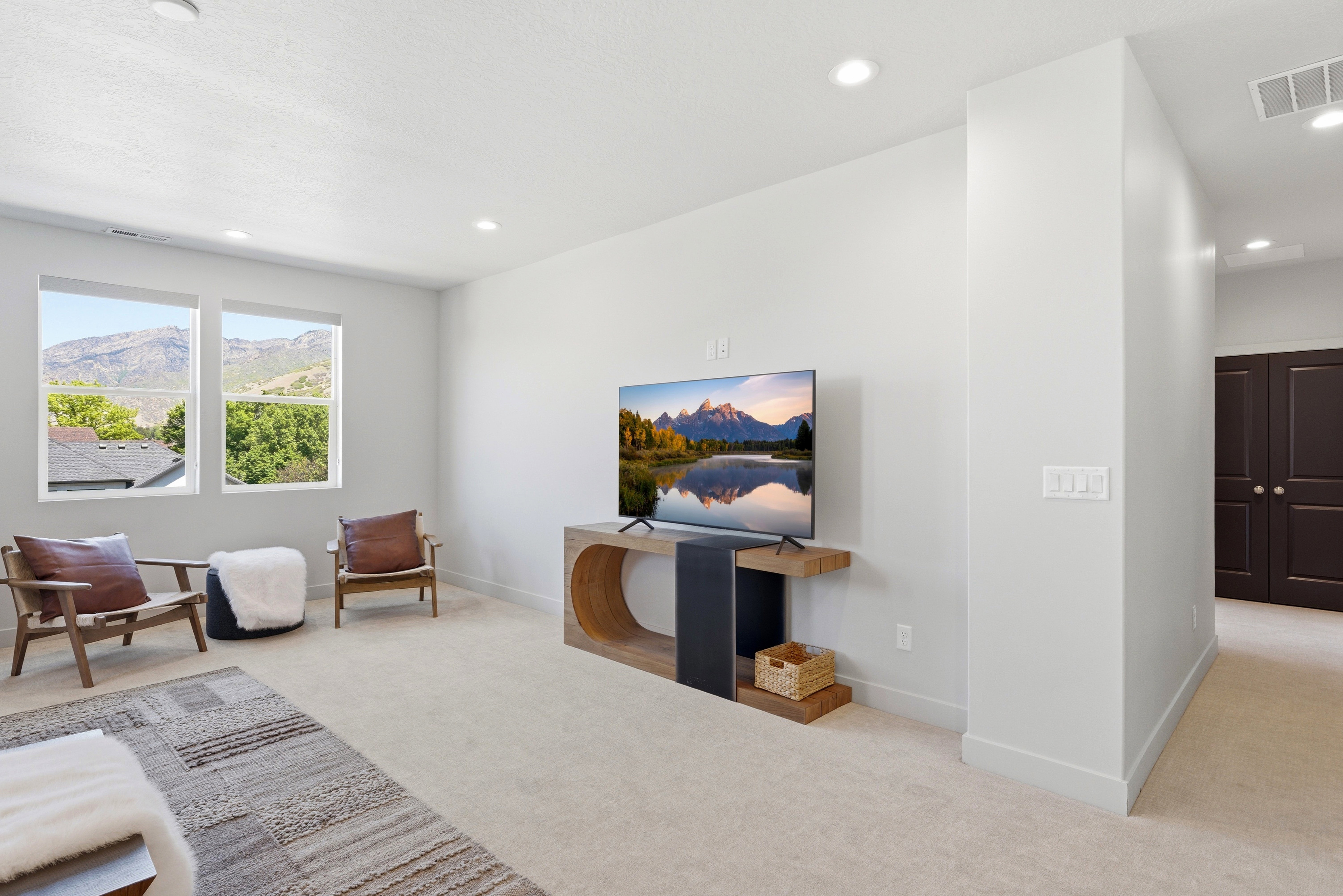 Carpeted room featuring multiple windows with mountain and tree scenery