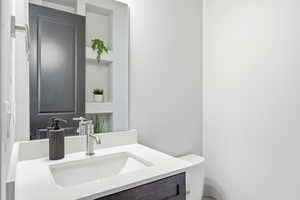 Bathroom vanity with an integrated rectangular sink, white countertop, dark wood-finish cabinetry, and a contemporary chrome faucet