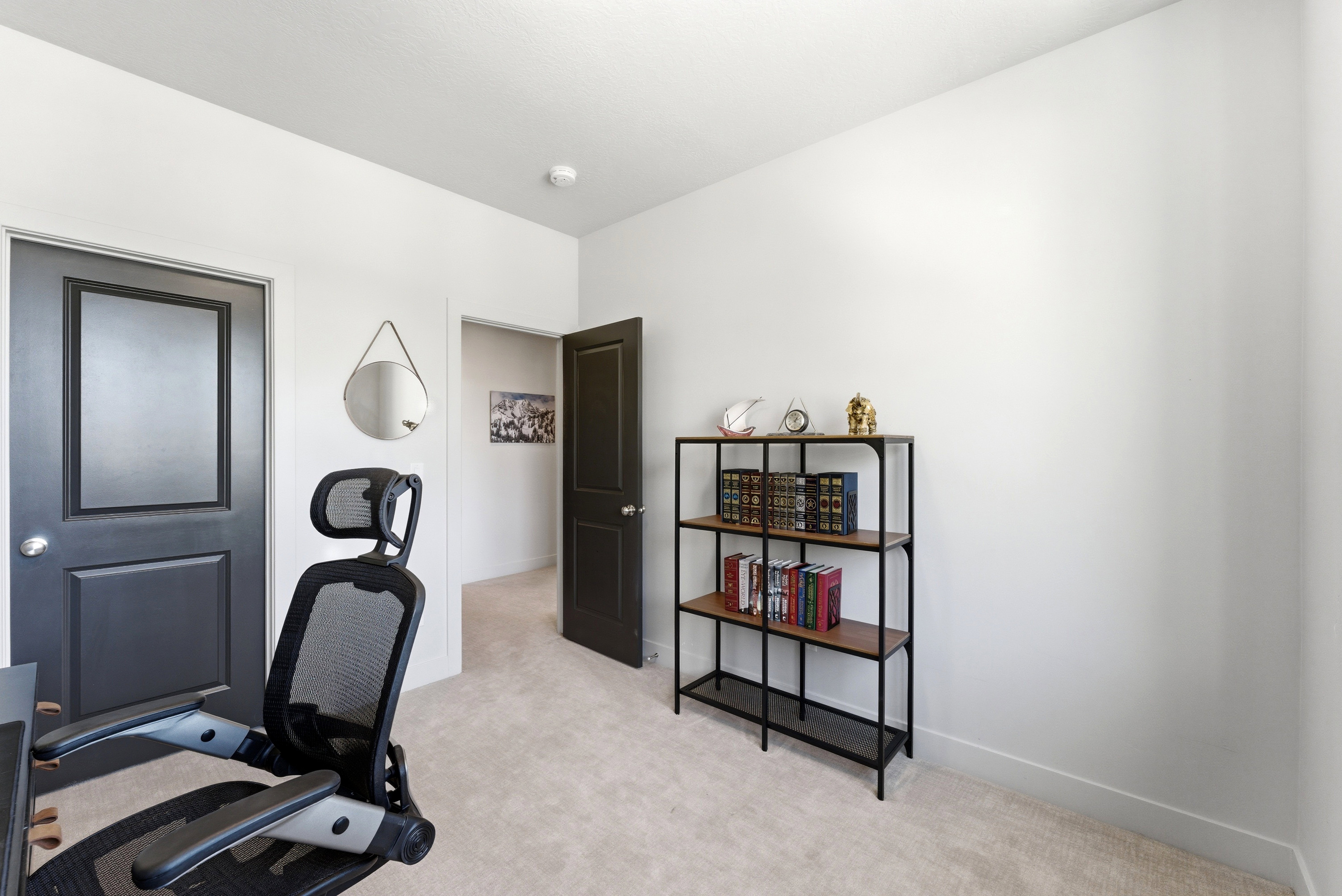 Carpeted room with light-colored walls and dark paneled doors