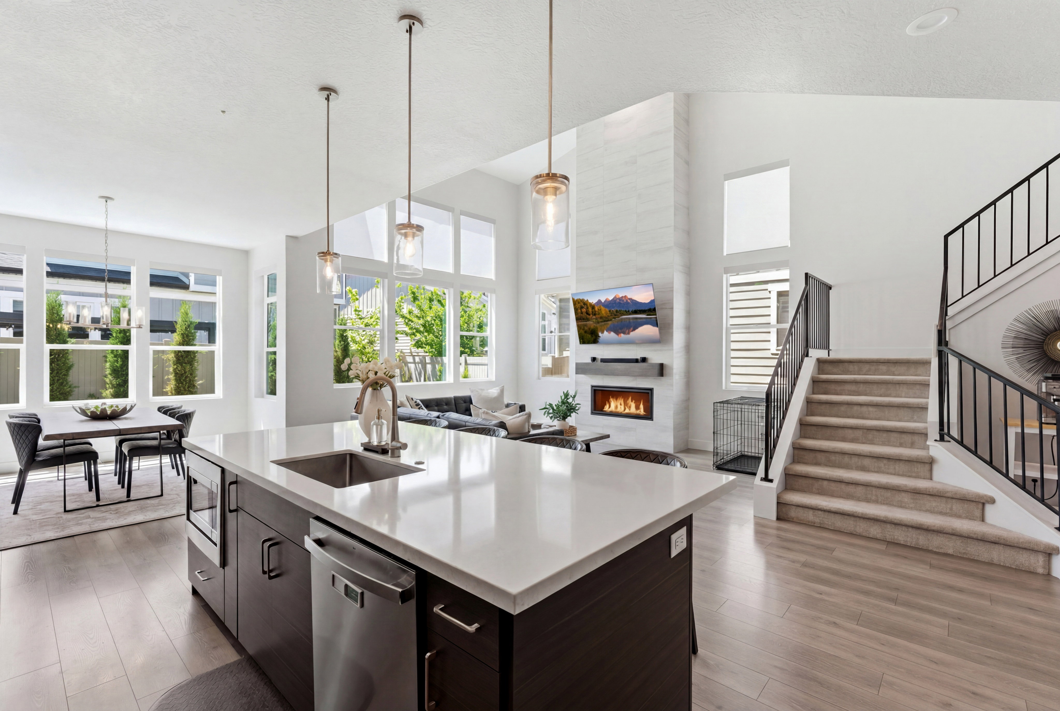 Open-concept living space featuring a modern kitchen island with an undermount sink, stainless steel dishwasher, and microwave drawer