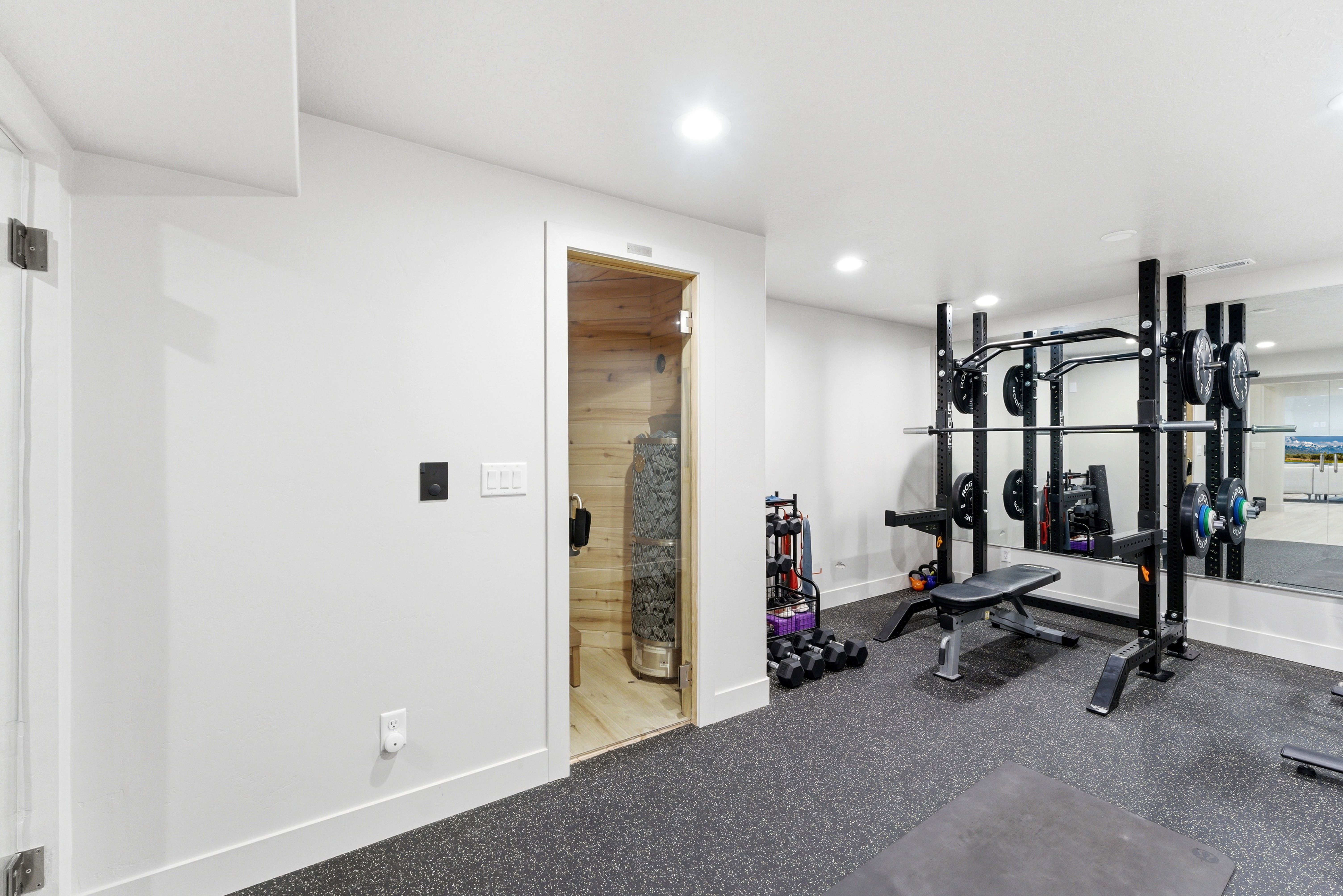 Dedicated fitness space featuring rubber flooring, recessed lighting, and a full-wall mirror