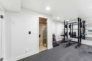 Dedicated fitness space featuring rubber flooring, recessed lighting, and a full-wall mirror