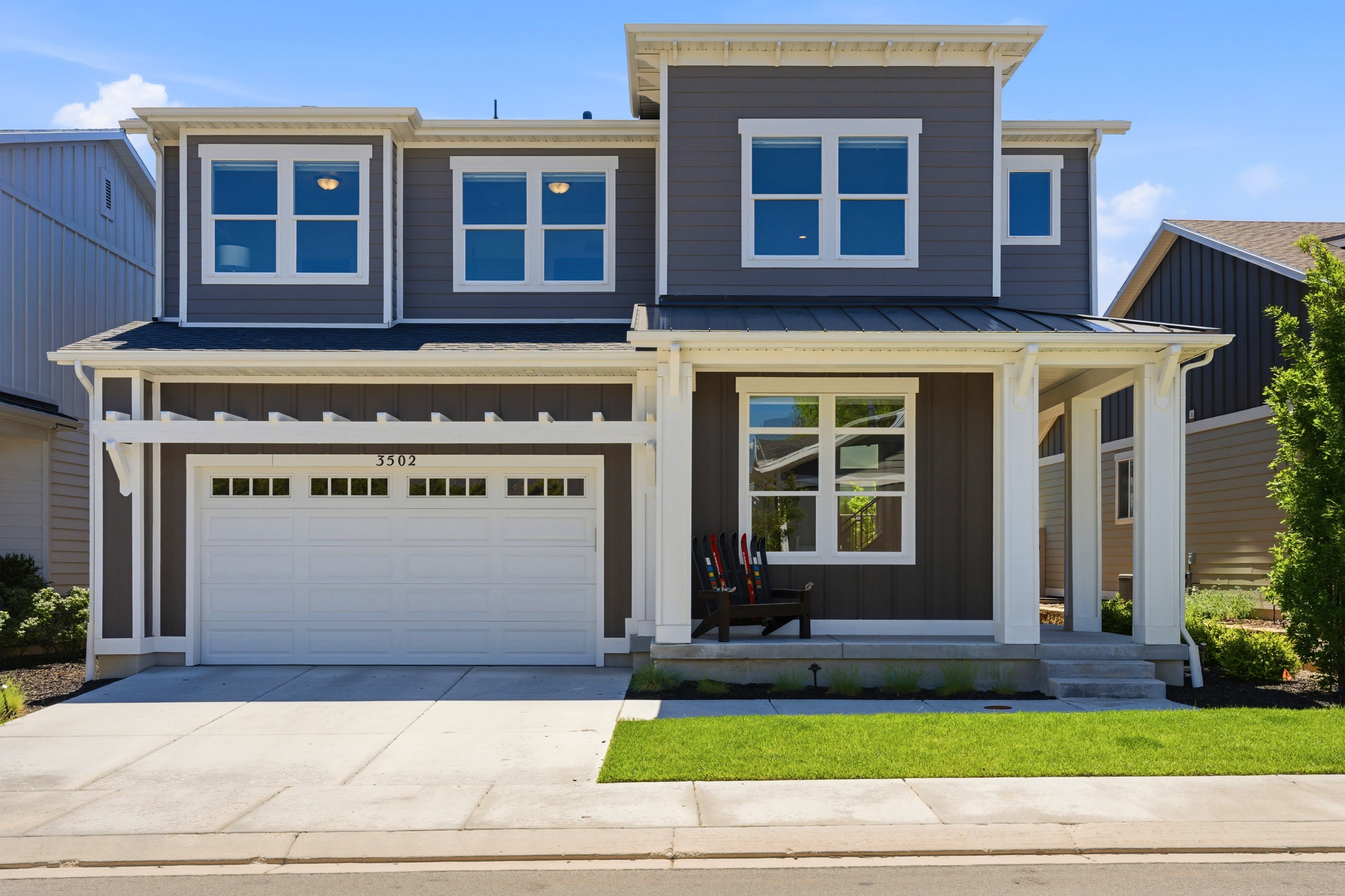 Contemporary two-story residence featuring dark gray vertical siding and white trim