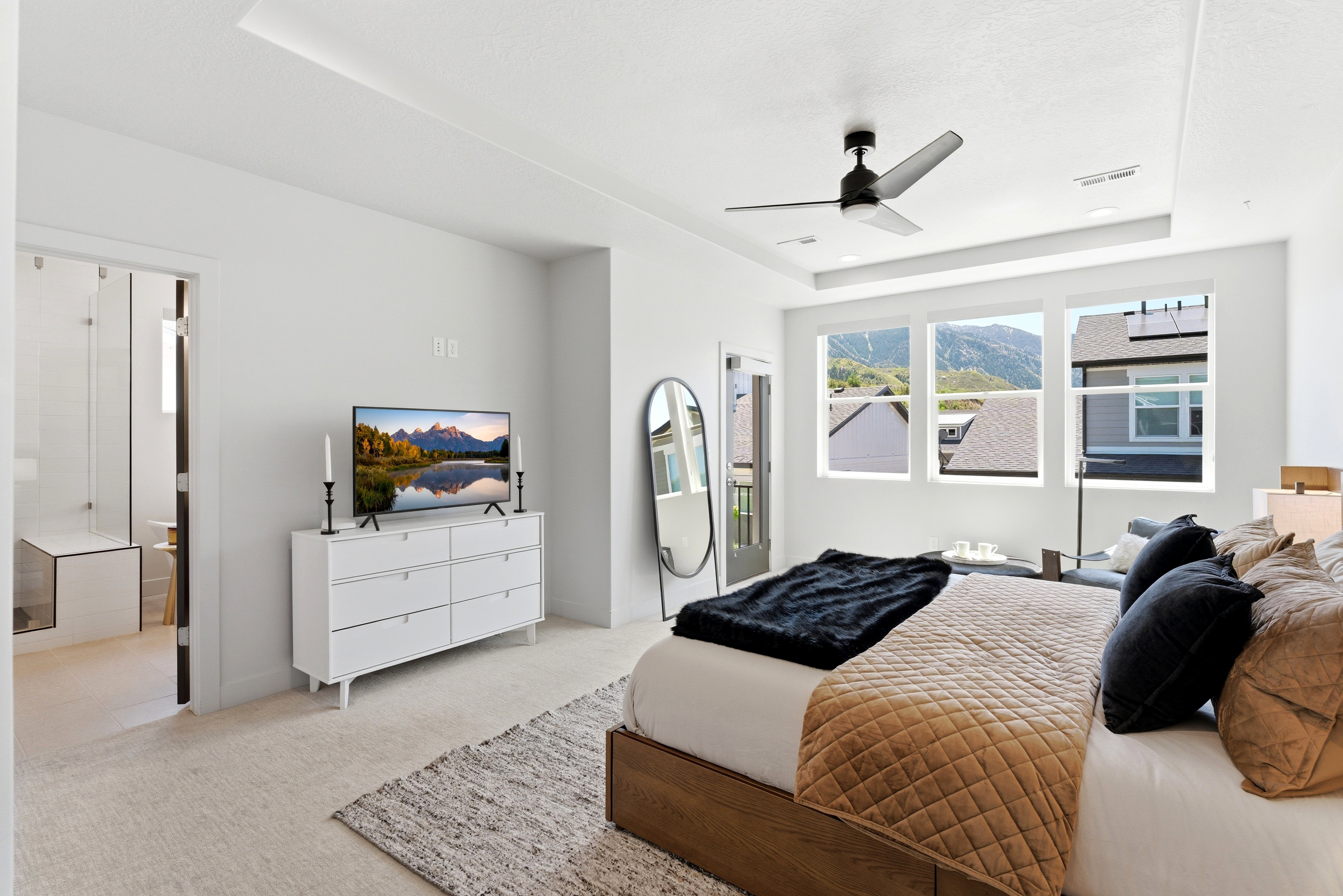 Bright bedroom featuring a tray ceiling with recessed lighting and a ceiling fan