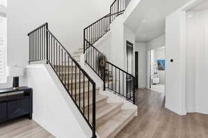 Entryway featuring a multi-level staircase with black iron railings and carpeted treads