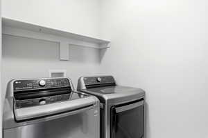 Dedicated laundry space with light gray walls and a built-in white shelf