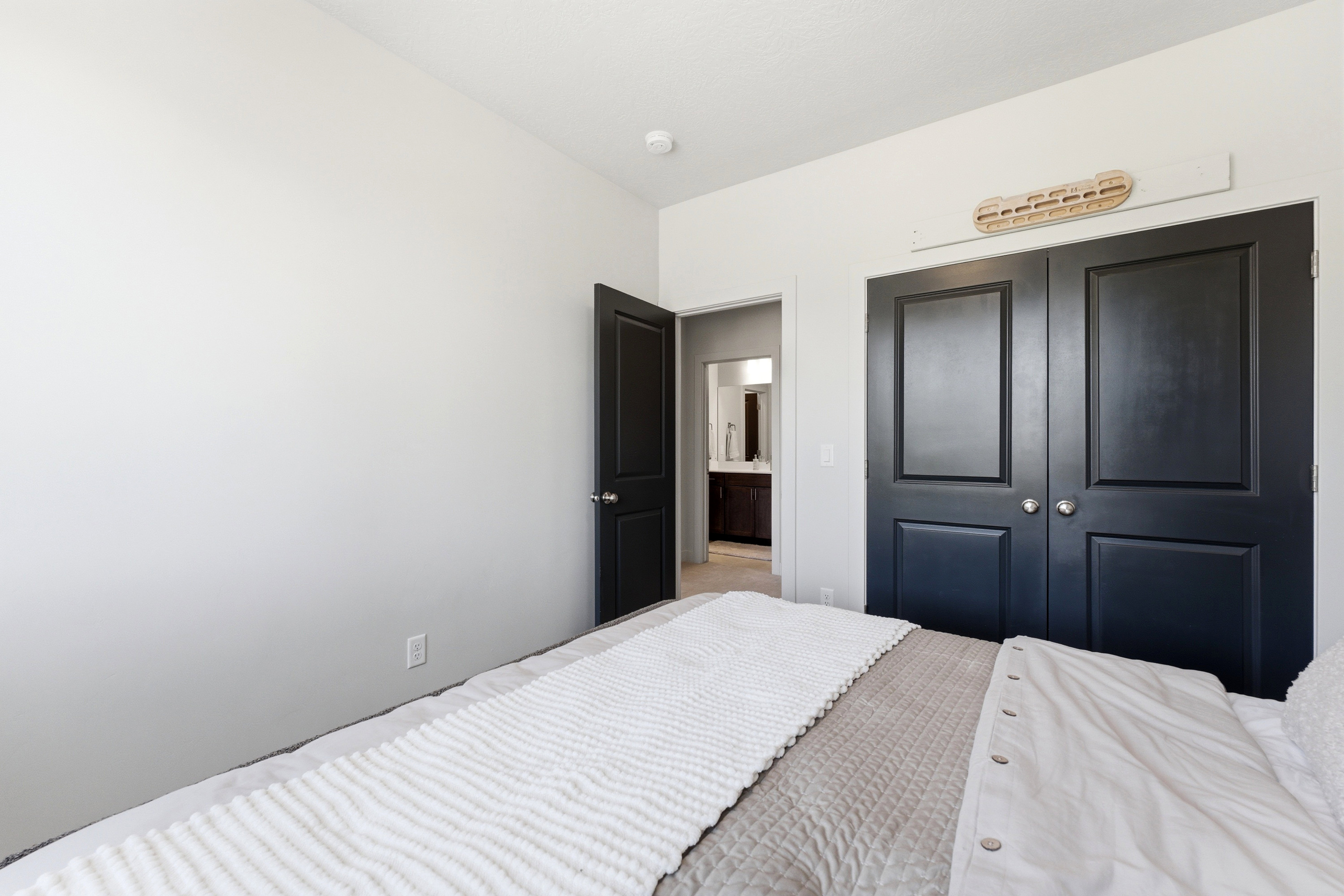 Bedroom featuring a double-door closet with panel detailing, a single paneled door, and light-colored walls