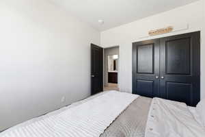 Bedroom featuring a double-door closet with panel detailing, a single paneled door, and light-colored walls