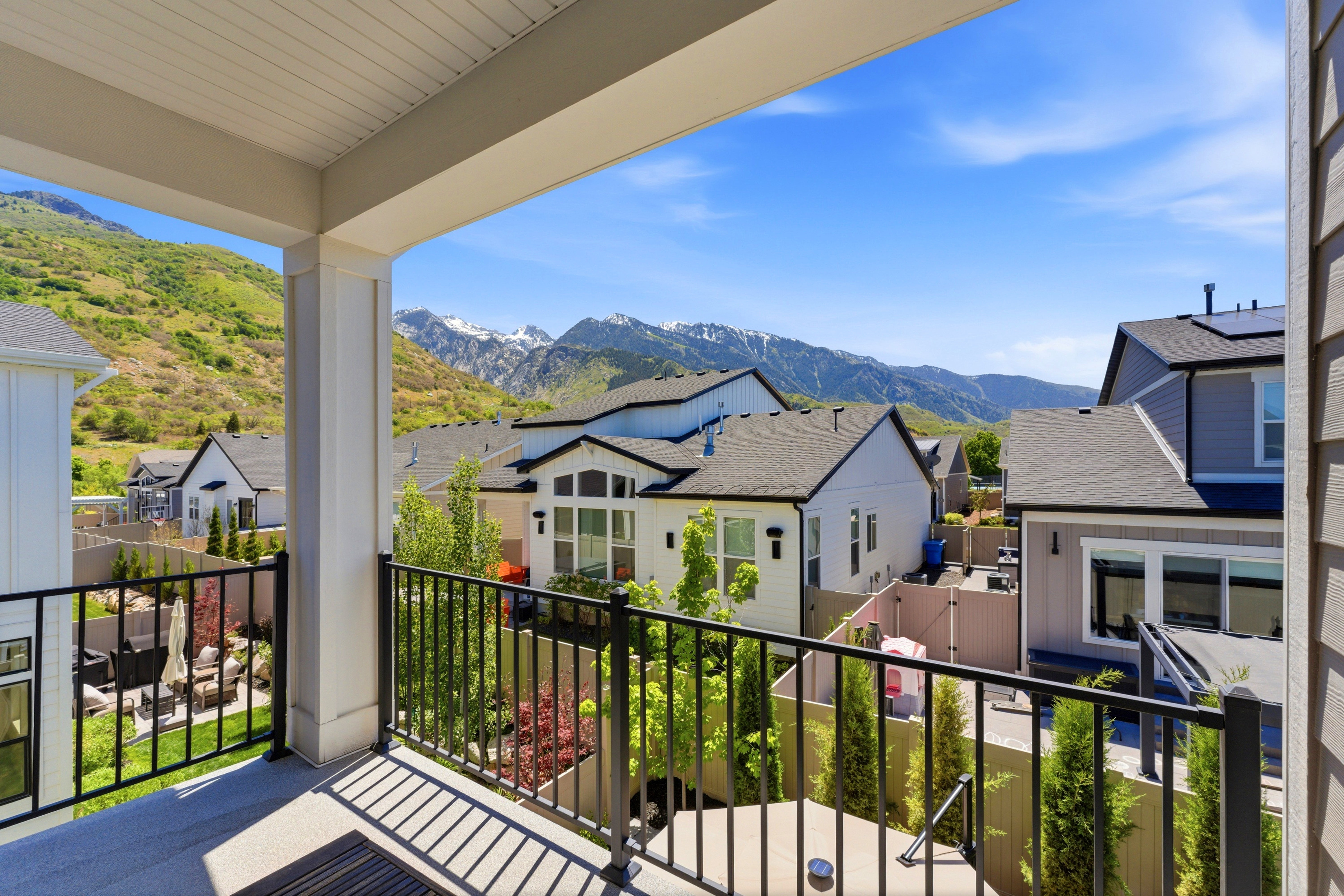 Covered outdoor balcony with black metal railings