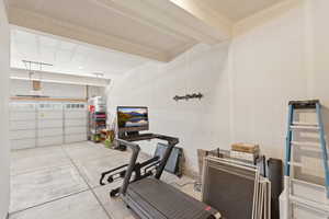 Spacious garage featuring a concrete floor, painted walls, and a two-car garage door with upper window panels