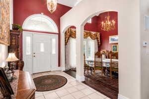 Grand entryway featuring a double door with decorative glass inserts and a transom window