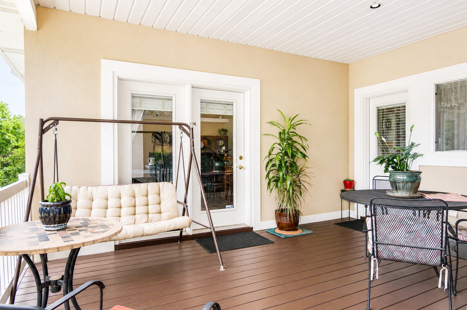Covered outdoor deck with rich brown wood-finish flooring