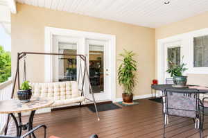 Covered outdoor deck with rich brown wood-finish flooring