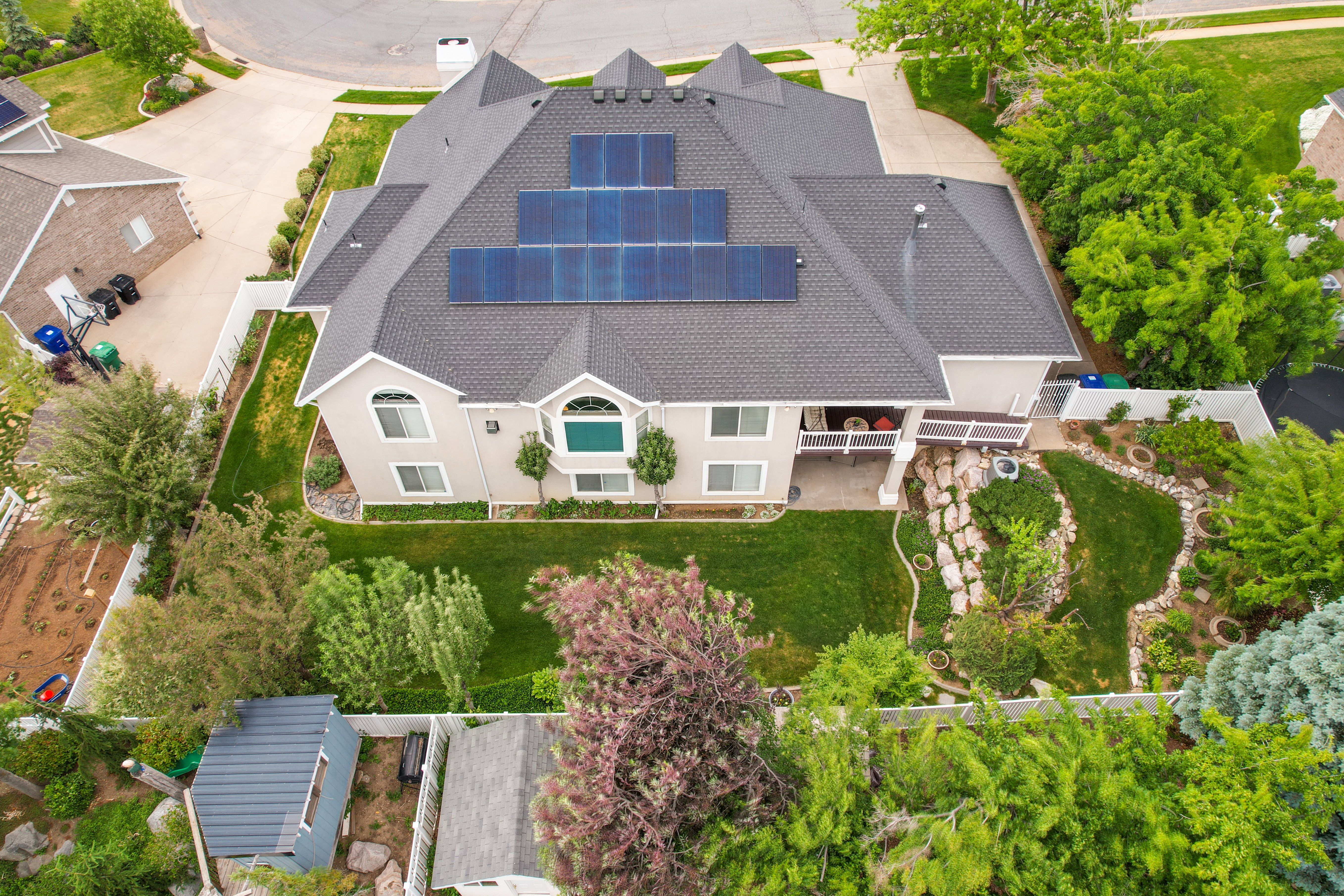 Two-story property featuring a multi-gabled roofline and multiple solar panel arrays