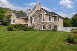 Stucco exterior with stone accents, a multi-gabled roof, and white window trim