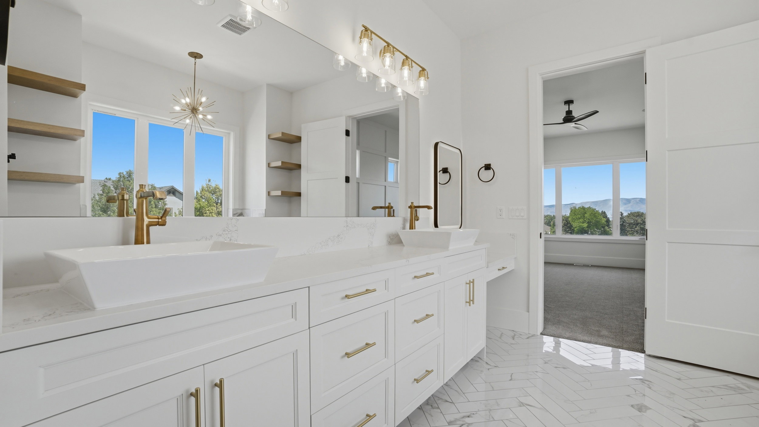 Dual vanity with white cabinetry, gold-finish hardware, and vessel sinks