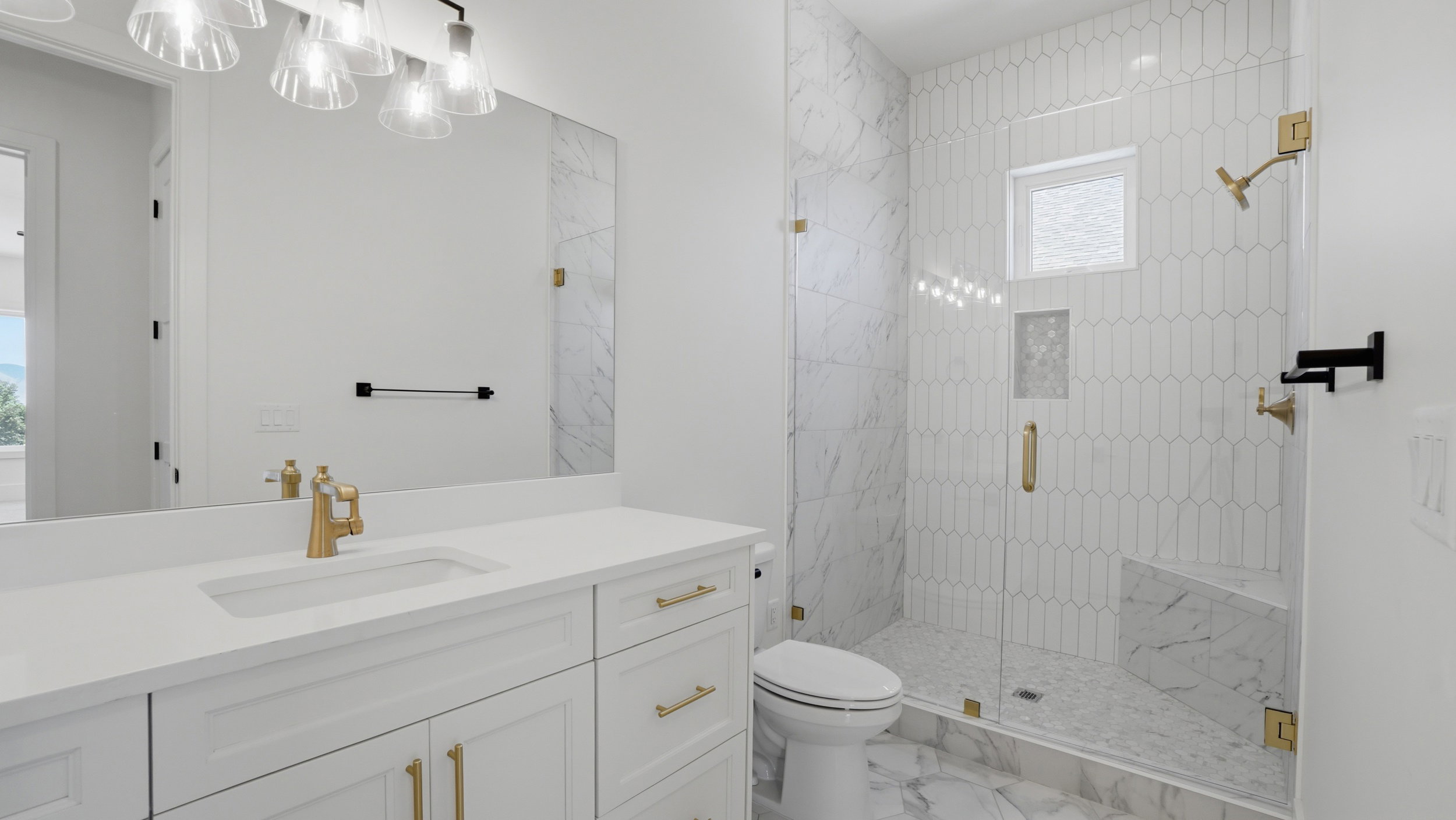 Spacious bathroom featuring a frameless glass shower enclosure with a built-in bench and a window