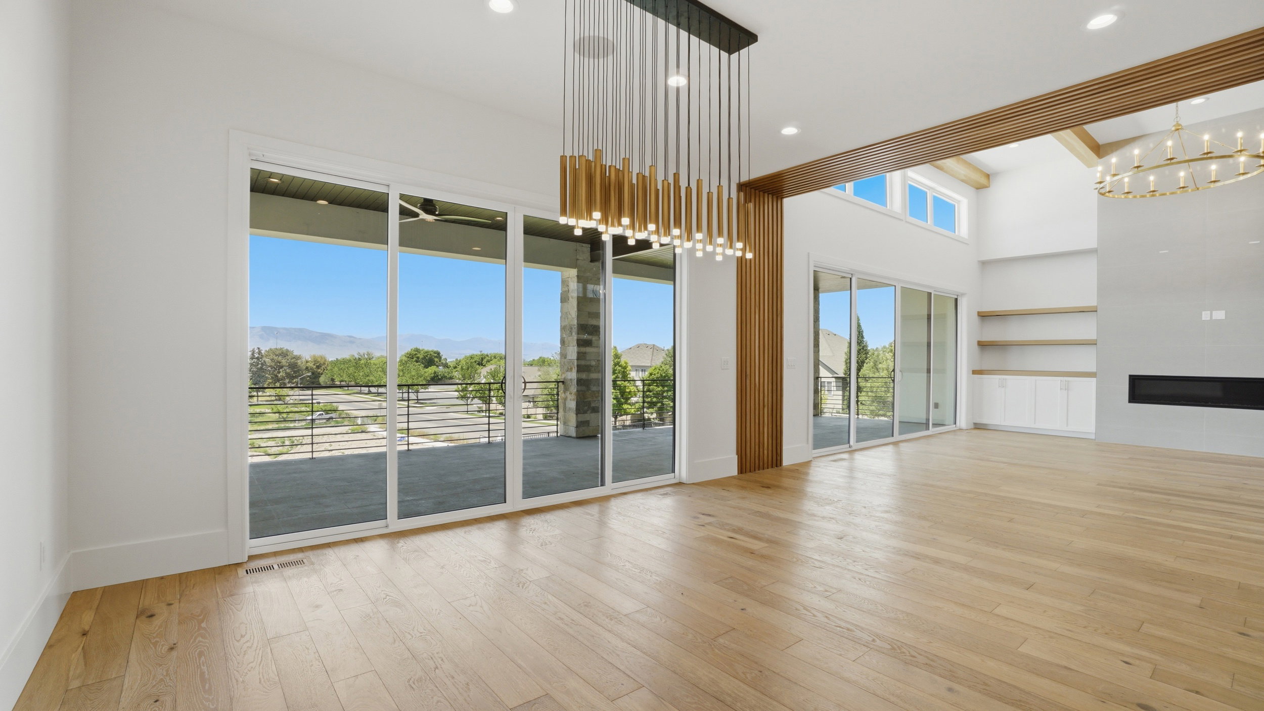 Hardwood-finish flooring extending through an open-concept living area with a high vaulted ceiling