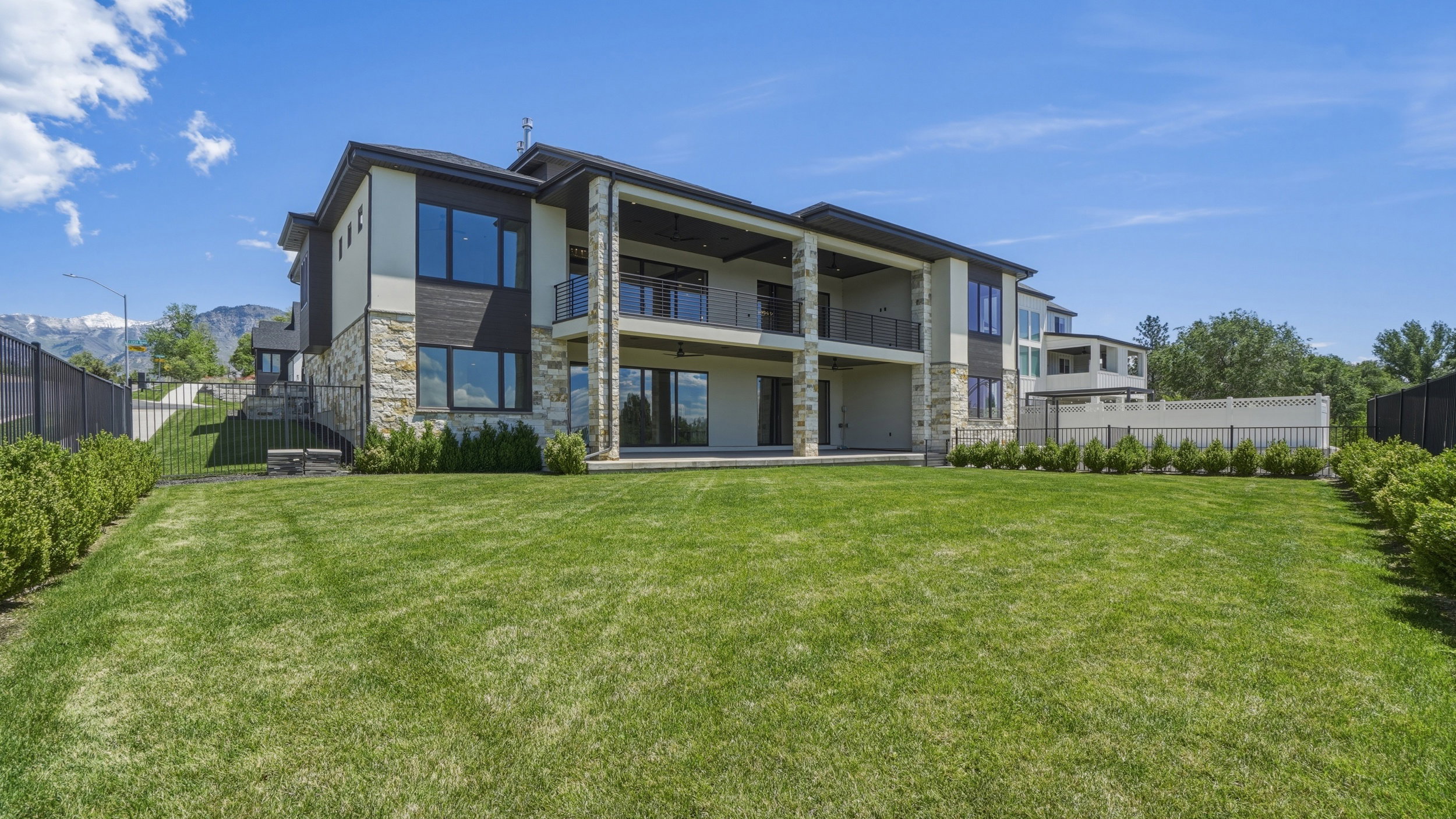 Expansive rear exterior featuring a multi-story design with stone accents and large windows