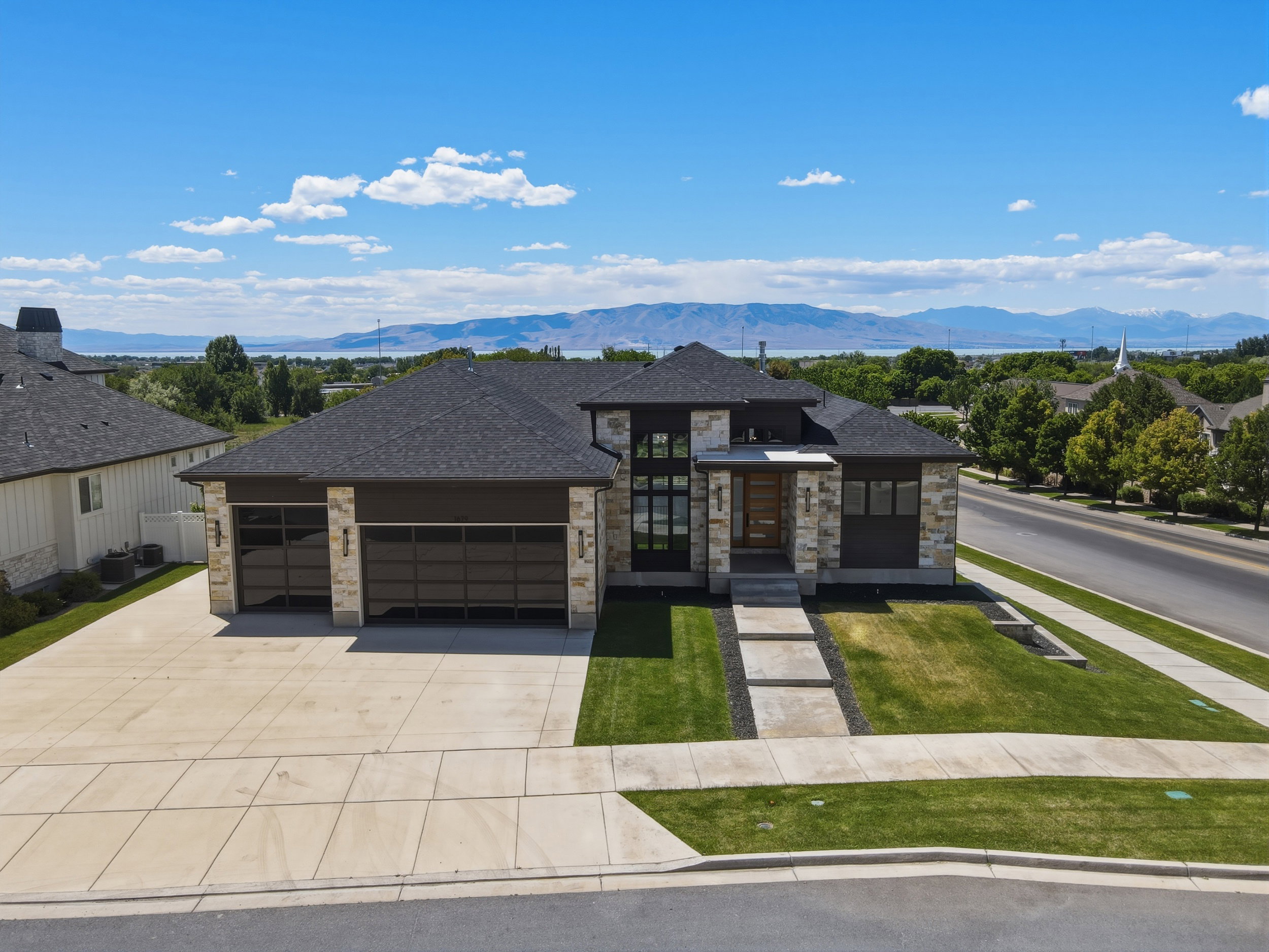 Contemporary-style residence featuring a stone and dark-panel exterior