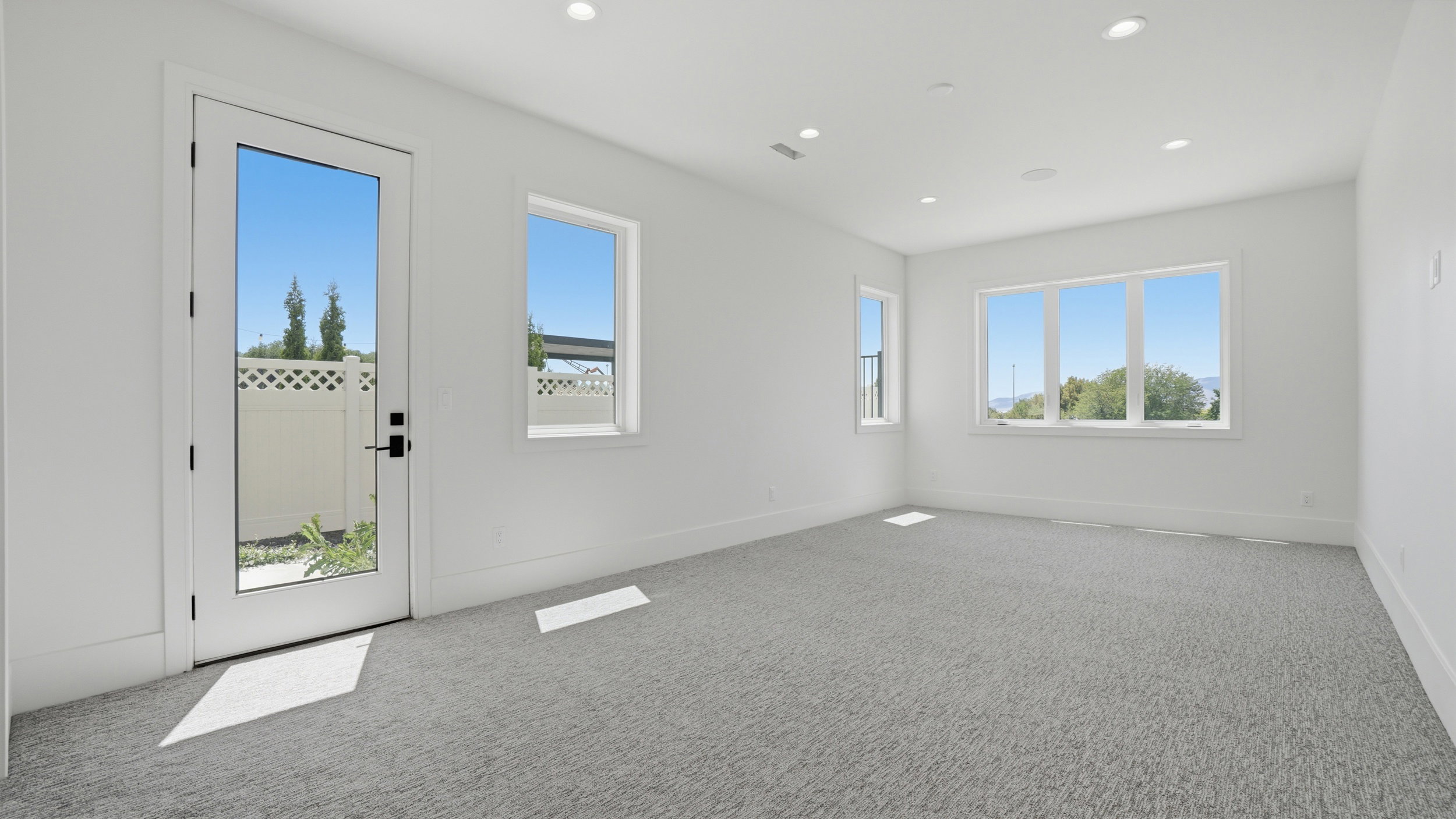 Bright room featuring light gray carpeting and white walls