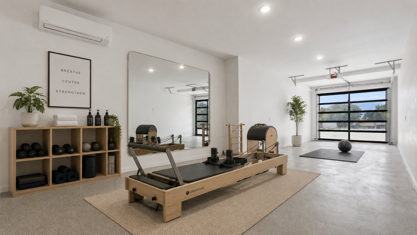 Spacious room featuring a full-width glass garage door, recessed lighting, and a wall-mounted air conditioning unit AI Pilates Option with flexspace