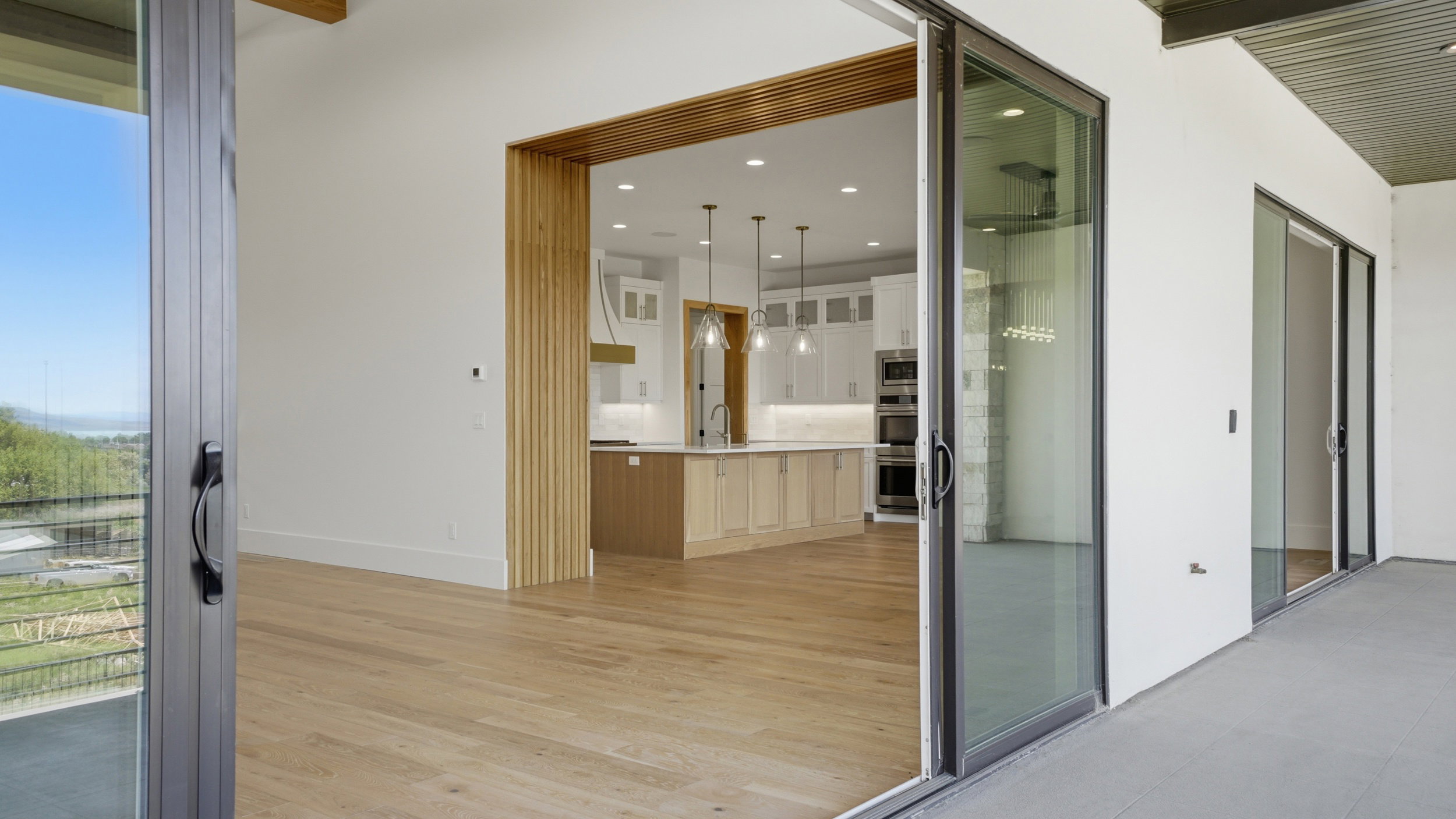 Sliding glass doors opening to an outdoor patio with a mountain backdrop