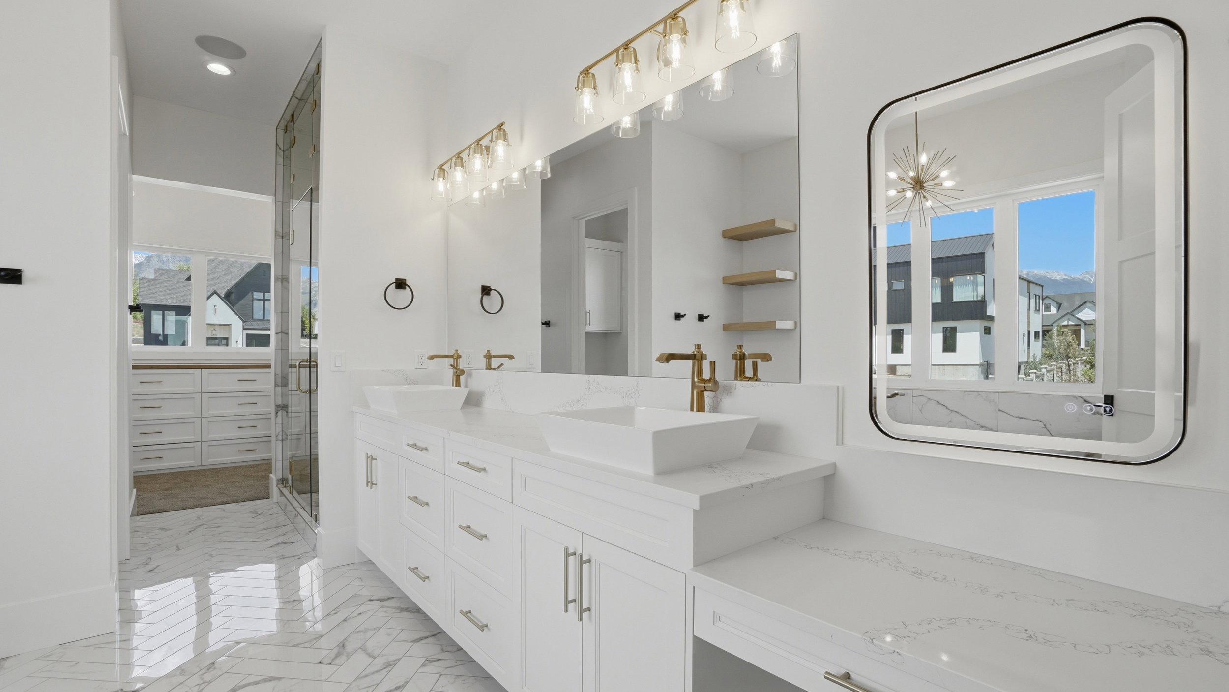 Double vanity with white cabinetry, quartz countertops, and gold-finish fixtures