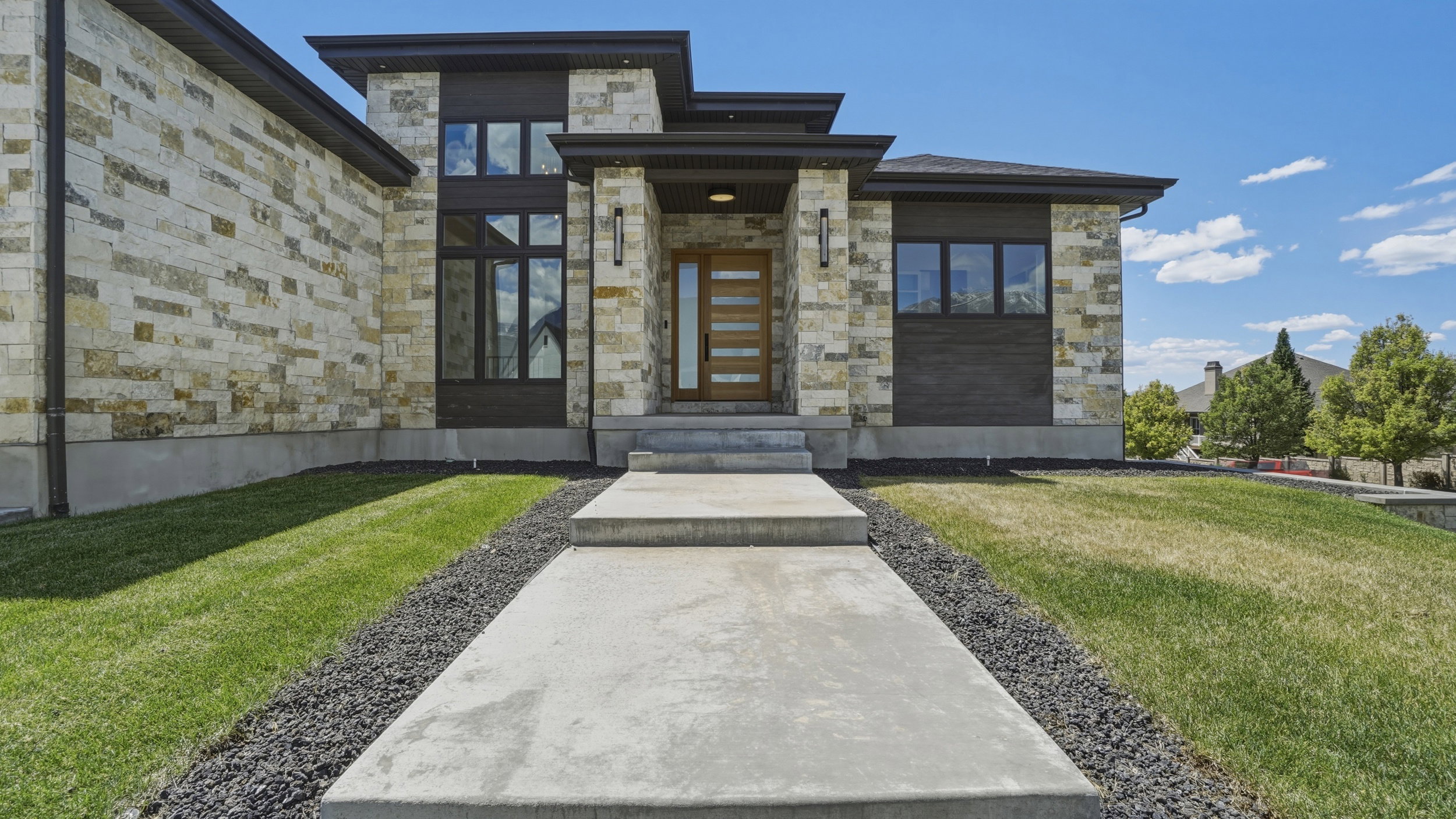 Modern architectural design featuring stacked stone and dark wood-finish paneling