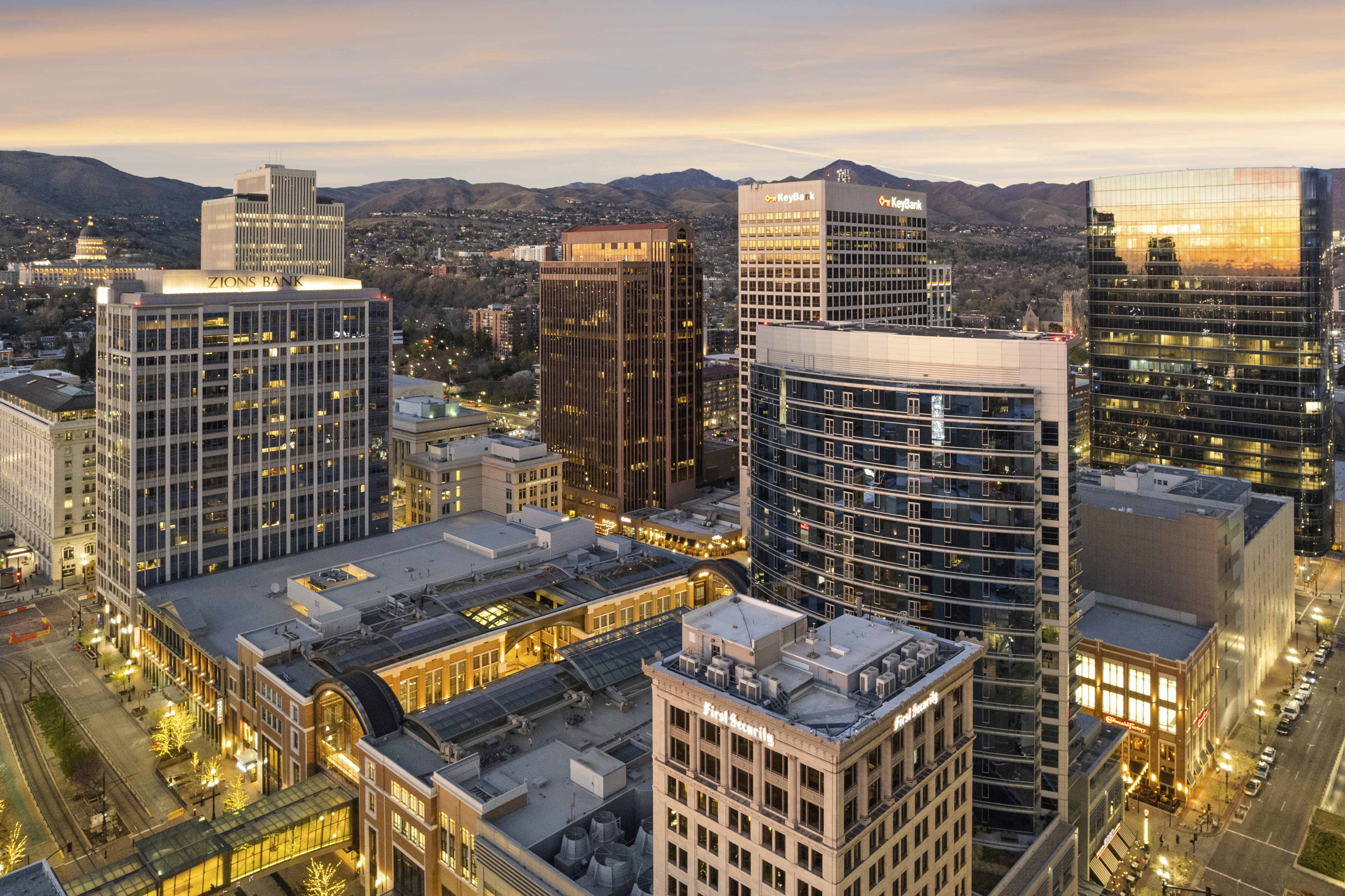 Panoramic city skyline featuring numerous high-rise buildings and distant mountains